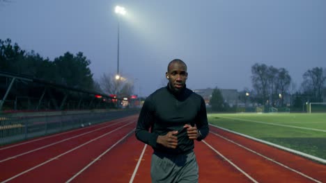 man running on a track at night