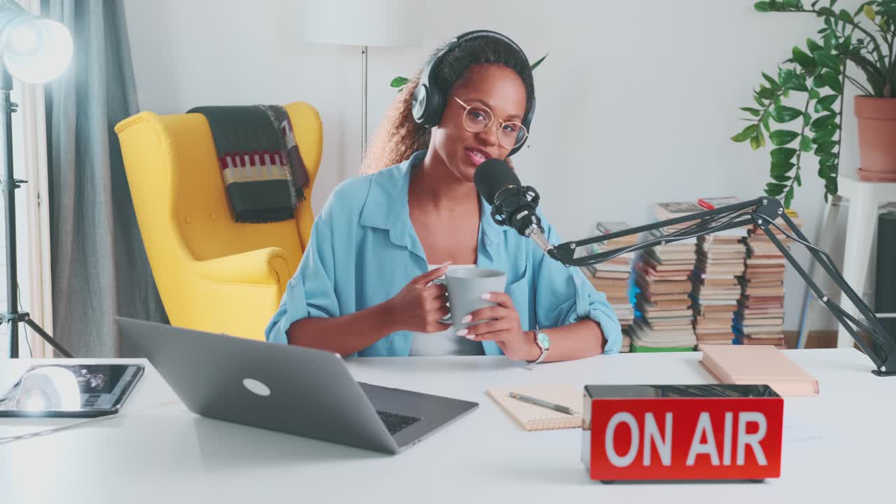 Young positive pretty african american woman blogger hosts audio podcast