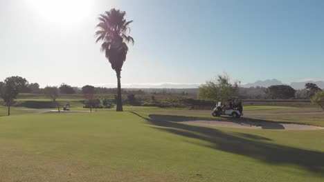 landschaftliche aussicht auf einen männlichen golfspieler, der auf dem golfplatz einen golfwagen fährt