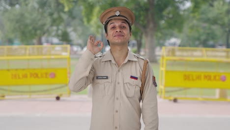 happy indian police officer showing okay sign