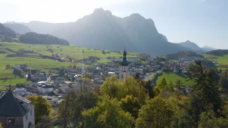 vuelo aéreo bajo por encima de los árboles en otoño con paisaje de montaña en segundo plano.