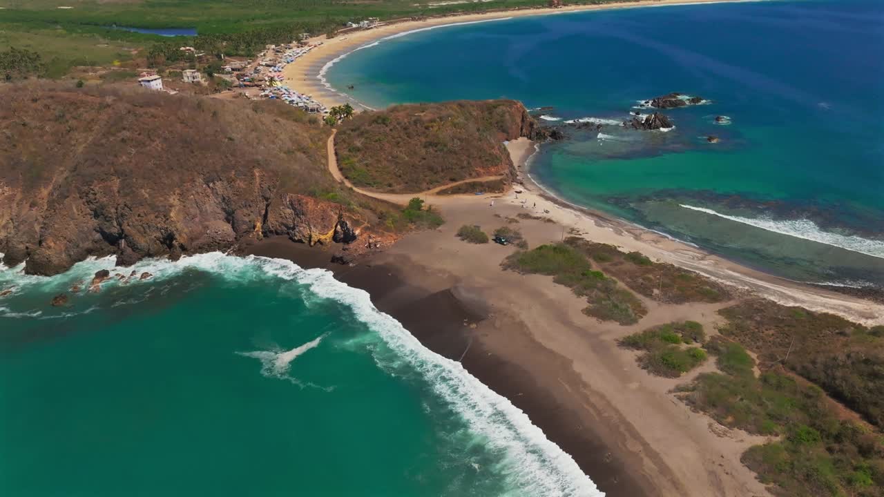 Panoramic view of La Morita beach peninsula, Mexico, featuring striking contrast between white and black sand, open ocean, and a coral reef bay. Tenacatita, Mexico