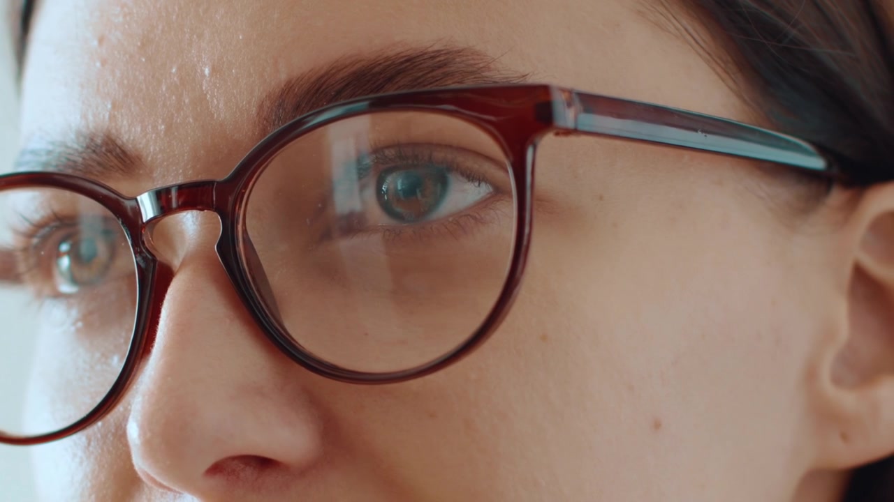 Close-up of a woman putting on her glasses
