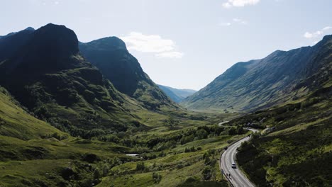 drone shot of cars driving through the glencoe valley in scotland