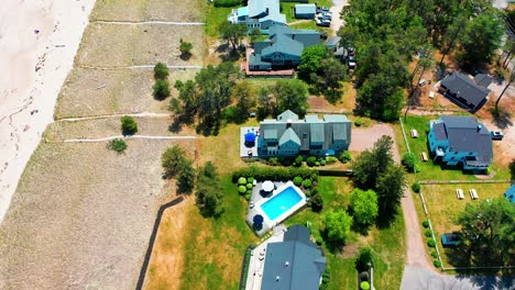 scenic drone view of a maine cottage with ocean views. deck, yard, patio, and windows make this prime coastal real estate perfect for family beach vacations and relaxing seaside living