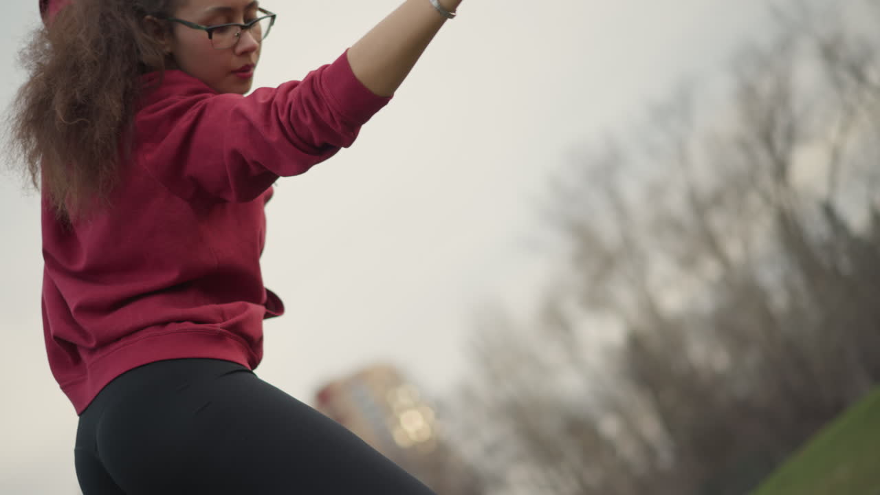 Sunset Scene Featuring Dancer In Casual Wear, Woman Moves Fluidly During Sunset With Bright Orange Band, Woman In Relaxed Active Attire Performs Dance Movements Against Soft Glowing Evening Sky