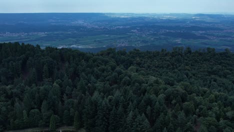 drone panorama of the ivrea morainic amphitheatre seen from brosso, val chiusella, italy, showing lush green plains, woods, and scattered villages under clear sky, high drone shot, slow motion