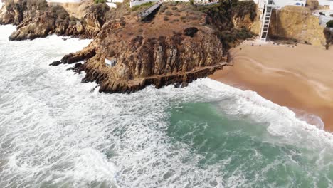 Olas-Que-Bañan-La-Playa-De-Arena-Y-Acantilados,-Albufeira,-Algarve,-Portugal