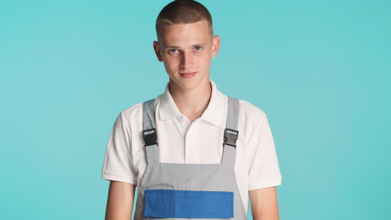 유니폼을 입은 젊은 금발 건축가, 포즈