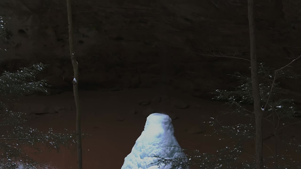 formación rocosa en la cueva de cenizas en invierno con acumulación de nieve en el suelo revelada
