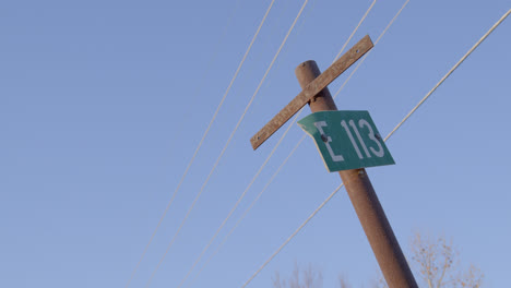 telephone pole e113 sign against a perfect blue sky in texas countryside