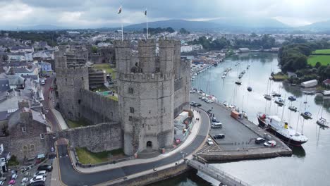 ancient caernarfon castle welsh harbour town aerial view medieval waterfront landmark misty mountains background