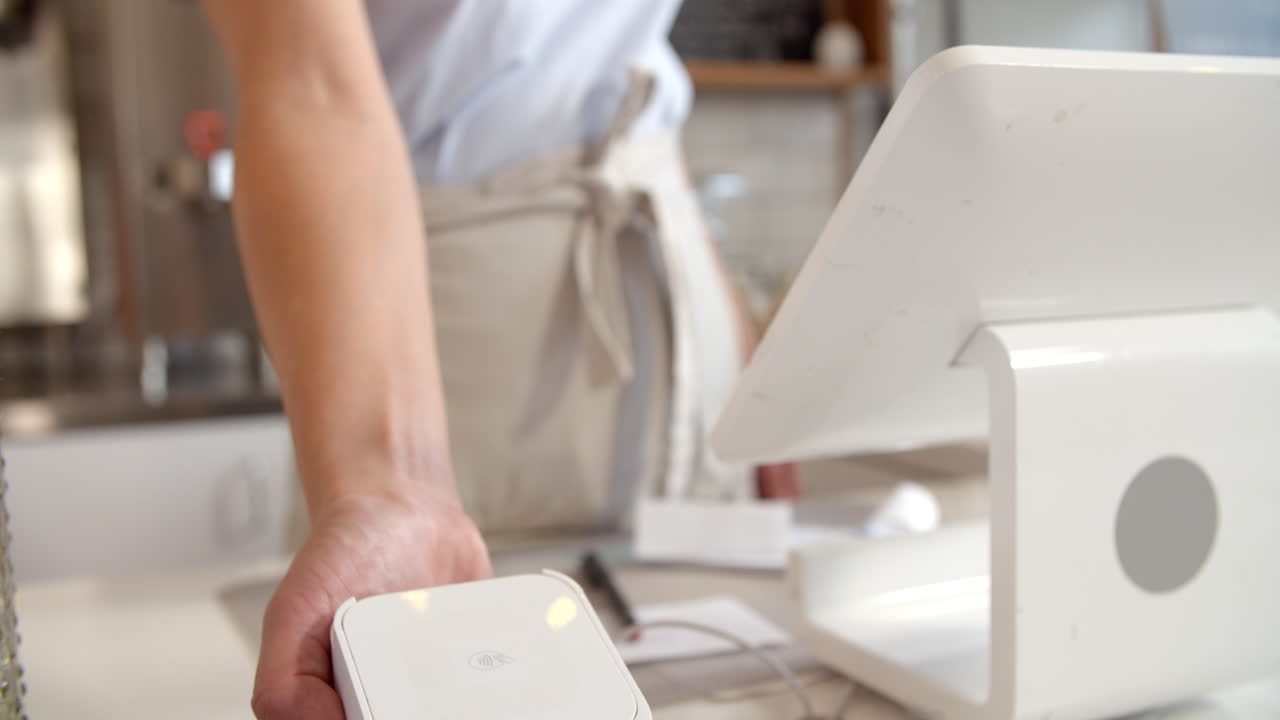 el barista acepta el pago con tarjeta de crédito en una cafetería, de cerca.