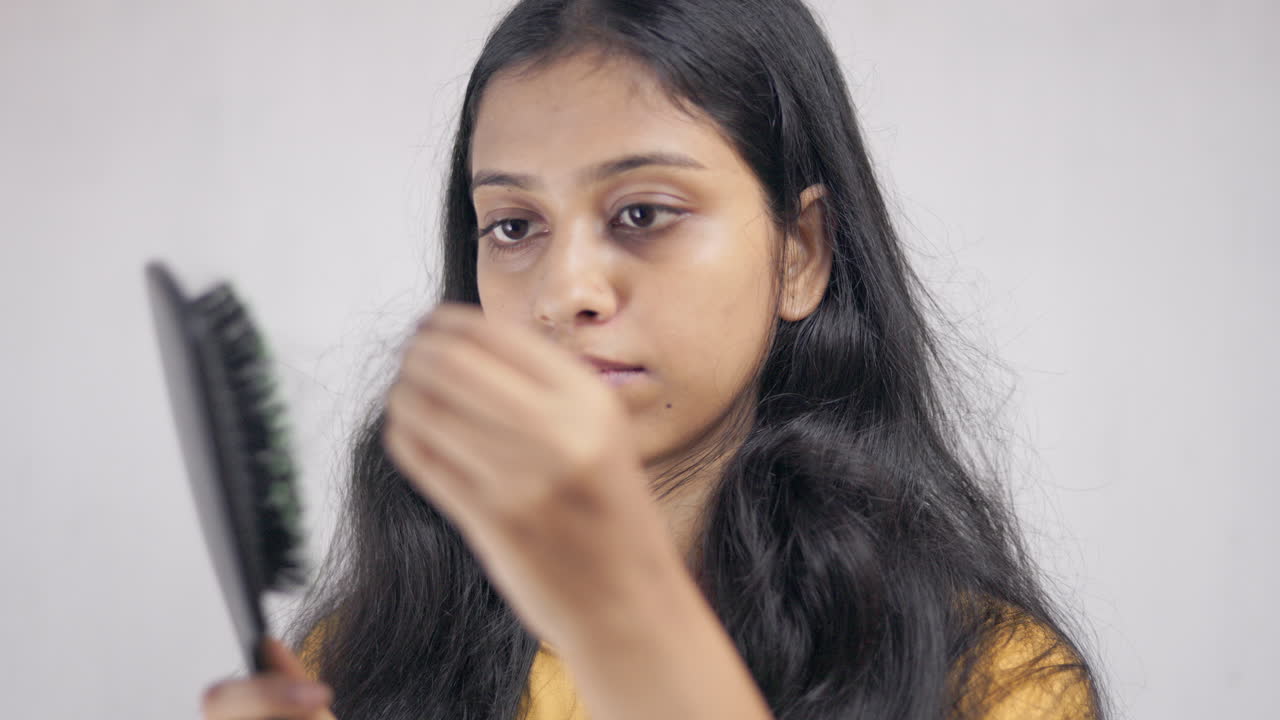 Indian young girl get shocked when removing a lot of fallen hair from the comb, worried about hair thinning,