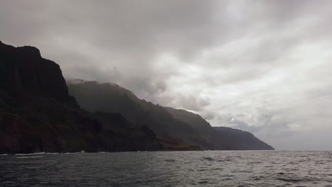 4K-Hawaii-Kauai-Boating-on-ocean-slow-right-to-left-pan-of-mountains-along-cloudy-shoreline