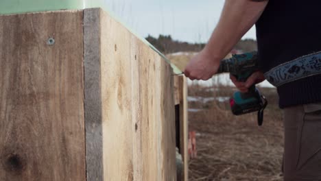 Close-Up-Of-Man-Building-His-Hot-Tub-Outdoors