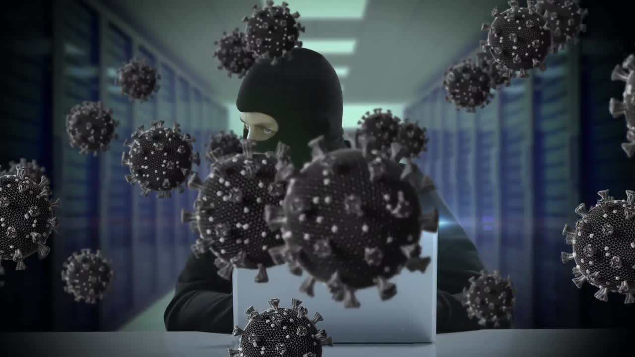 animación de las células macro covid19 sobre un hombre que lleva una balaclava, usando una computadora portátil