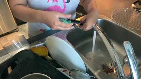 mujeres asiáticas lavando platos sucios