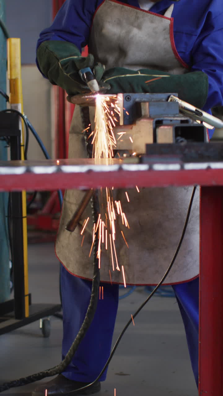 video vertical de la sección media de una mujer afroamericana mecánica de automóviles usando un molinillo