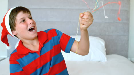 niño feliz usando popper de fiesta en el dormitorio