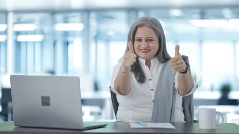 feliz mujer de negocios india senior mostrando pulgares hacia arriba