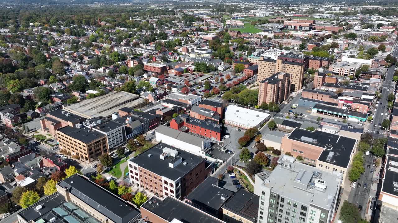 Drone flight over Lancaster Downtown with offices and apartment towers during sunny day. Colored trees in fall season. Historic old town of american town in Pennsylvania, USA