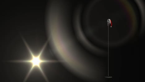 animation of light and vintage microphone in santa hat on black background