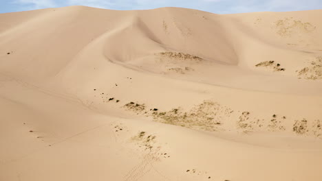 plataforma rodante aérea de dunas de arena y cielo azul en el desierto de gobi durante el día soleado