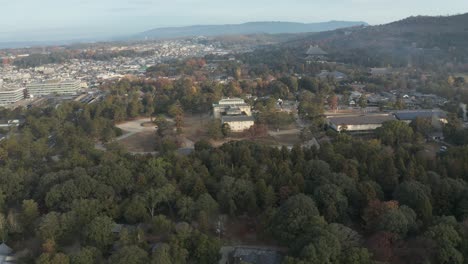 An-aerial-pan-of-Nara-City-and-Todaiji-Temple-with-mountains-in-the-background-in-Nara-Prefecture,-Japan