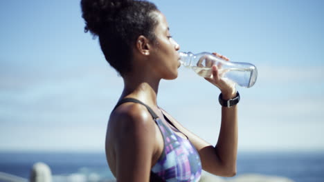 woman drinking water after workout