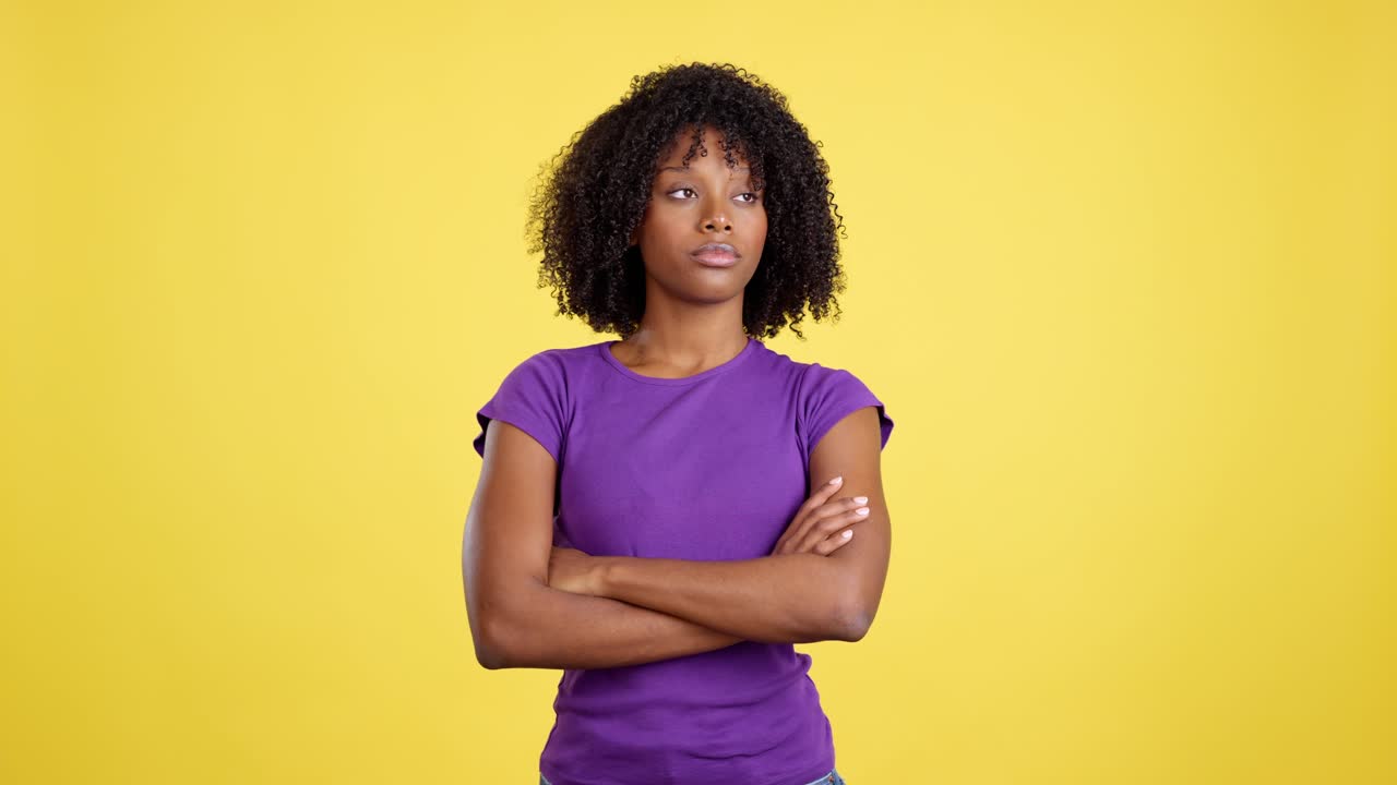 Serious Black Woman with Arms Crossed on Yellow Background