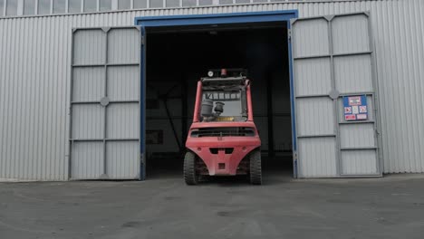 the big industrial forklift drives into the warehouse.