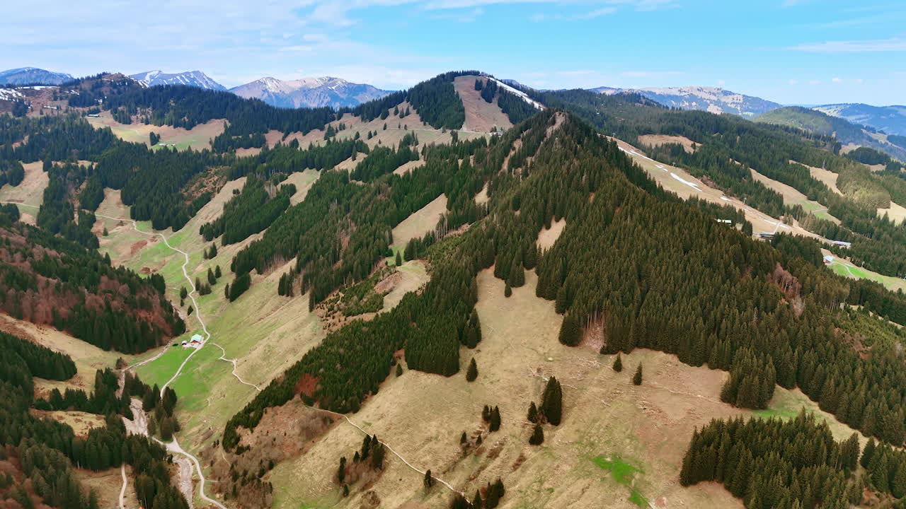 Enormous mountains with bare areas and wooded zones. Drone flight above the wilderness of Bavaria, Germany.
