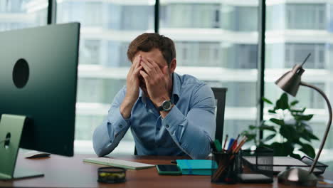 man feeling work crisis sitting at office table close up. manager disappointed.