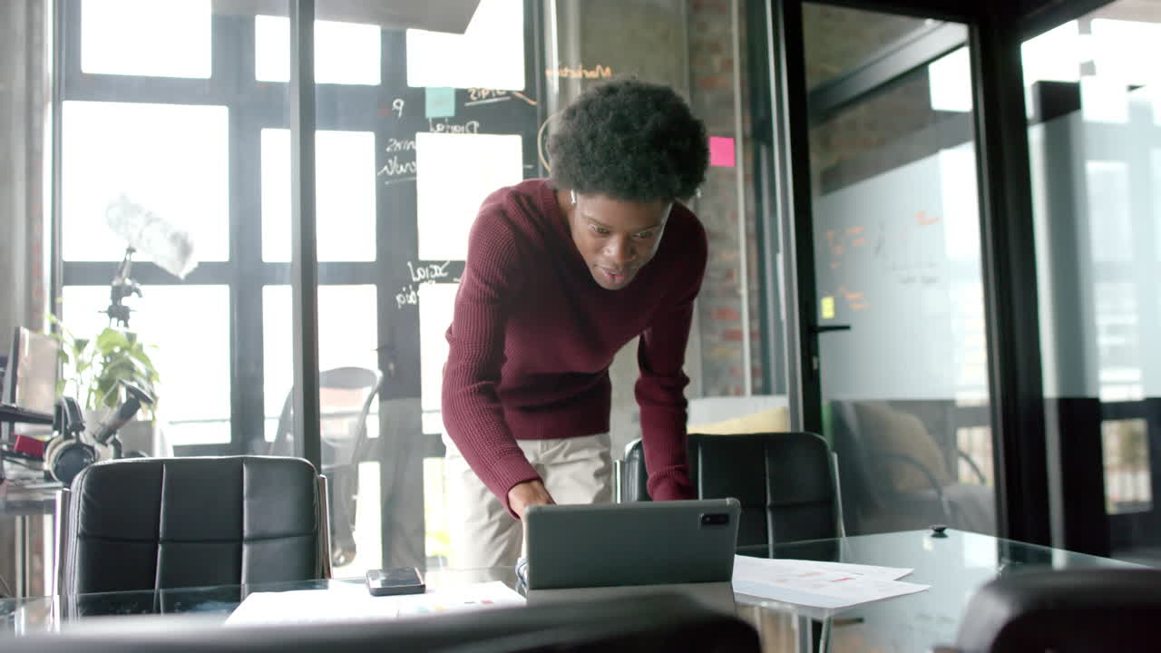 Uomo d'affari afroamericano in abiti casual che usa un tablet nell'ufficio di casa, slow motion, spazio per il testo