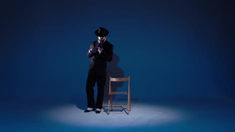stylish person in a suit and hat posing in a spotlight