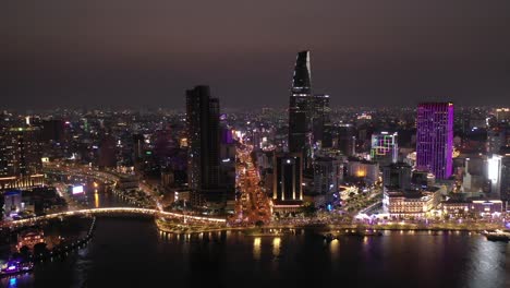 Ho-Chi-Minh-City,-Vietnam-iconic-Skyline-and-Saigon-river-waterfront-aerial-panorama-on-a-busy-evening-featuring-all-key-buildings-illuminated-against-beautiful-colored-sky