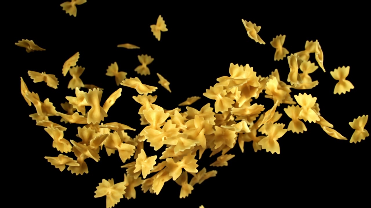 Pasta farfalle che cade al rallentatore su sfondo nero