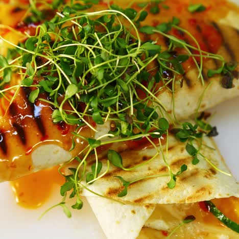 delicious dish in the restaurant. yummy pita poured with sauce on table.tasty meal decorated with green sprouts. ready to eat. close-up