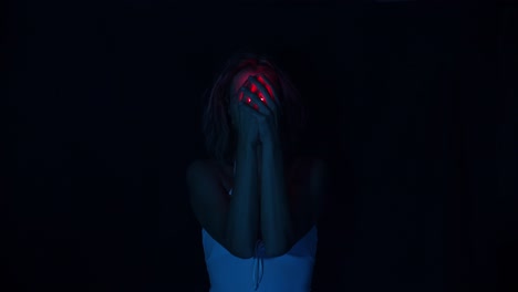 Woman-holding-a-red-neon-light-bulb-hiding-her-face