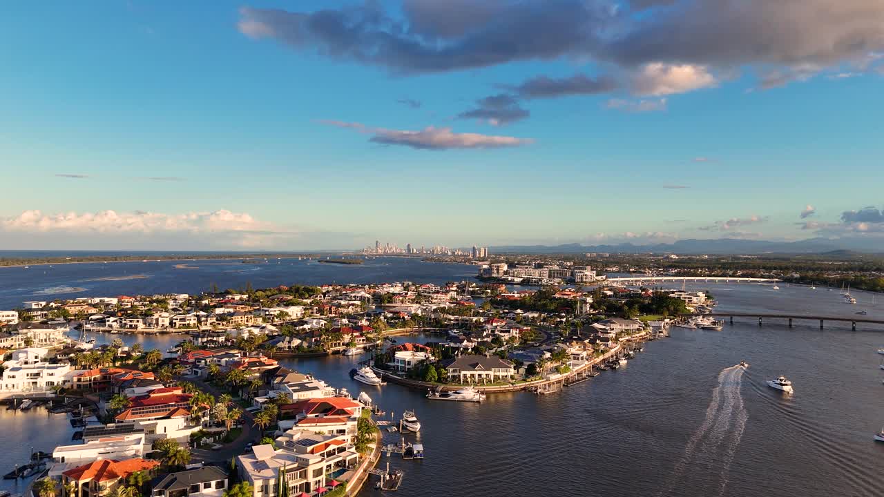 Drone footage captures Gold Coast's luxury estates and waterways at sunset, highlighting vibrant colors and serene atmosphere