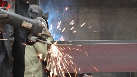 the grinder works at a metalwork factory and grinds metal parts with sparks