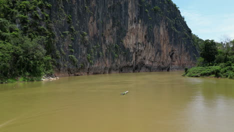 longtail fishing boats do their thing on brown mekong river in laos