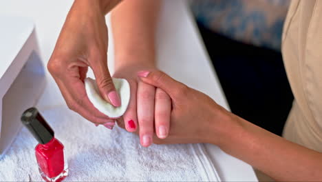 hands on woman at salon, cleaning nail polish