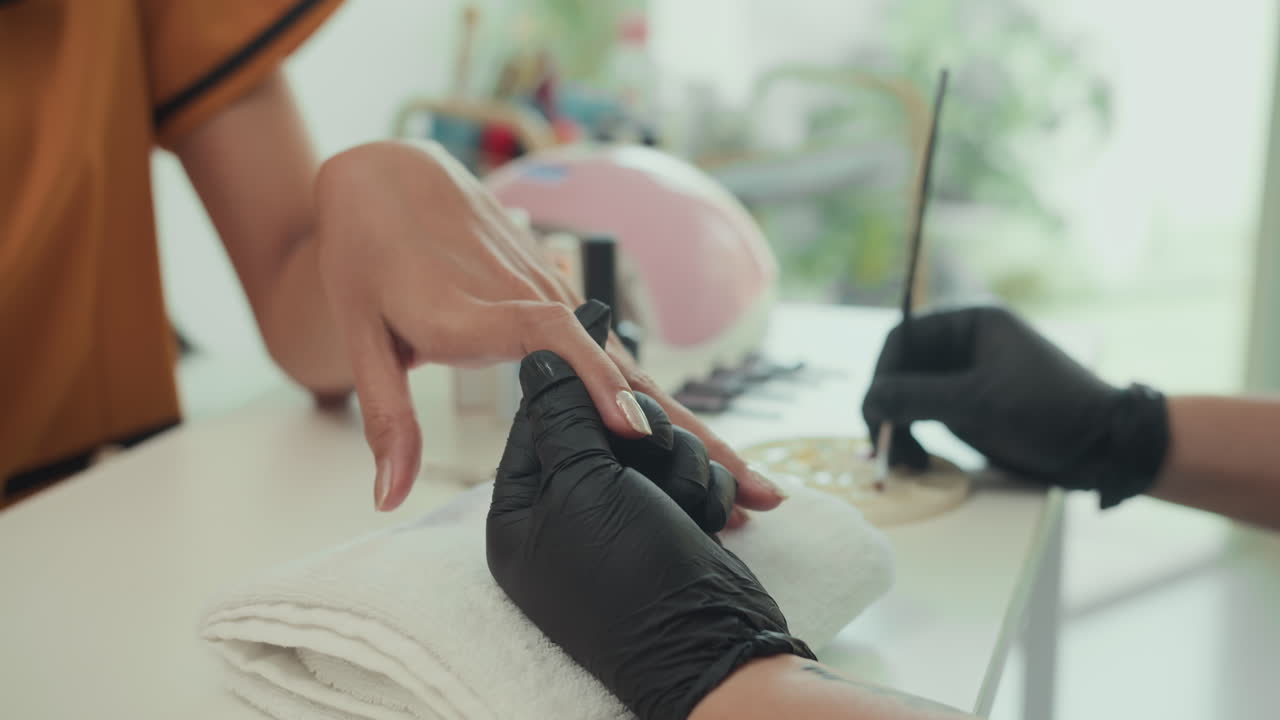 Unrecognizable Expert Covering Nails of Client with Decor