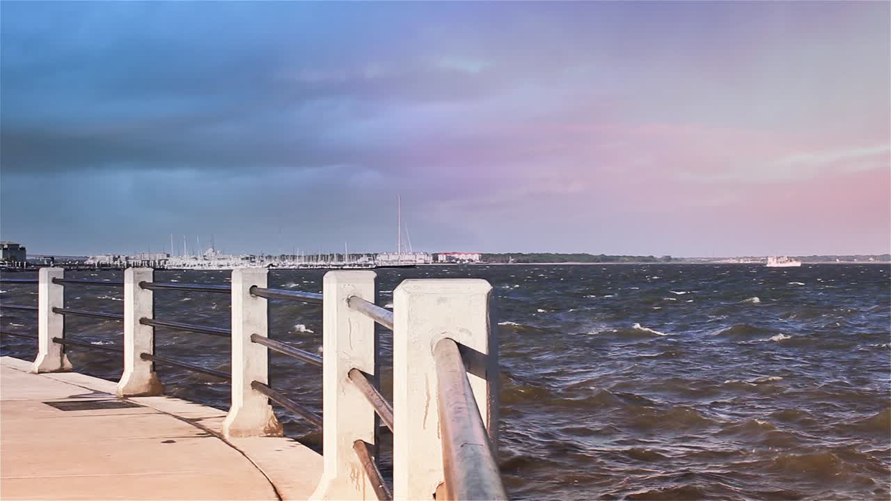 Malownicze nabrzeże z mariną, falującą wodą i kolorowym niebem