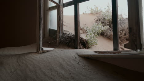 abandoned house covered in sand dunes