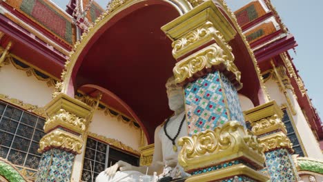 Big-monk-statue-sitting-in-meditation-at-thai-temple-in-Koh-Samui-in-panning-shot-low-angle-view