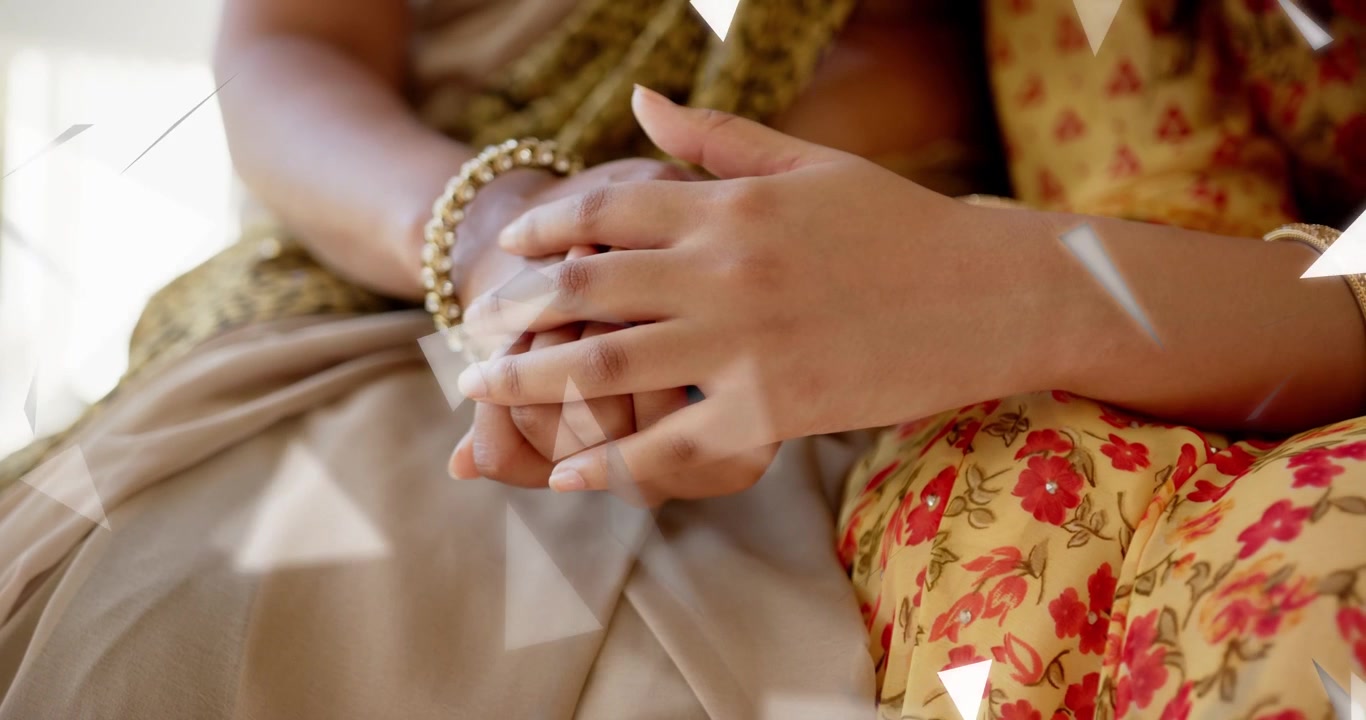 Madre e figlia che appoggiano le mani sul display, con sovrapposizioni a triangolo che fluttuano sulle mani mostrando dati sulla salute