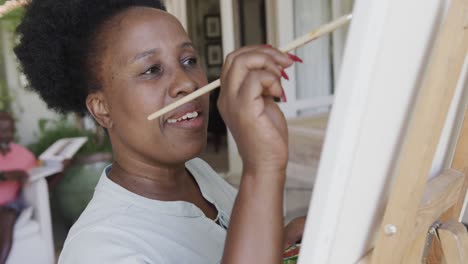 Happy-senior-african-american-woman-painting-in-slow-motion